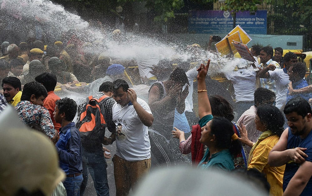 AAP workers being water cannoned while crossing the barricades during a protest against Delhi Police in New Delhi.