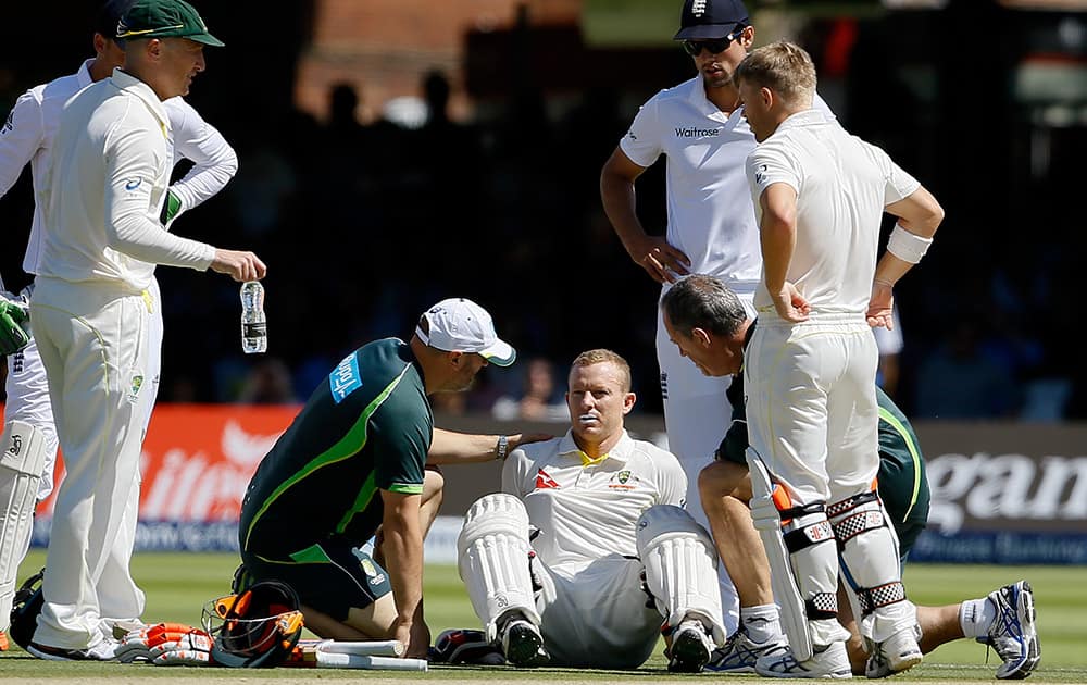 Australia's batsman Chris Rogers sits on the ground as he gets ill, and retires not out on the fourth day of the second Ashes Test match between England and Australia, at Lord's cricket ground in London.