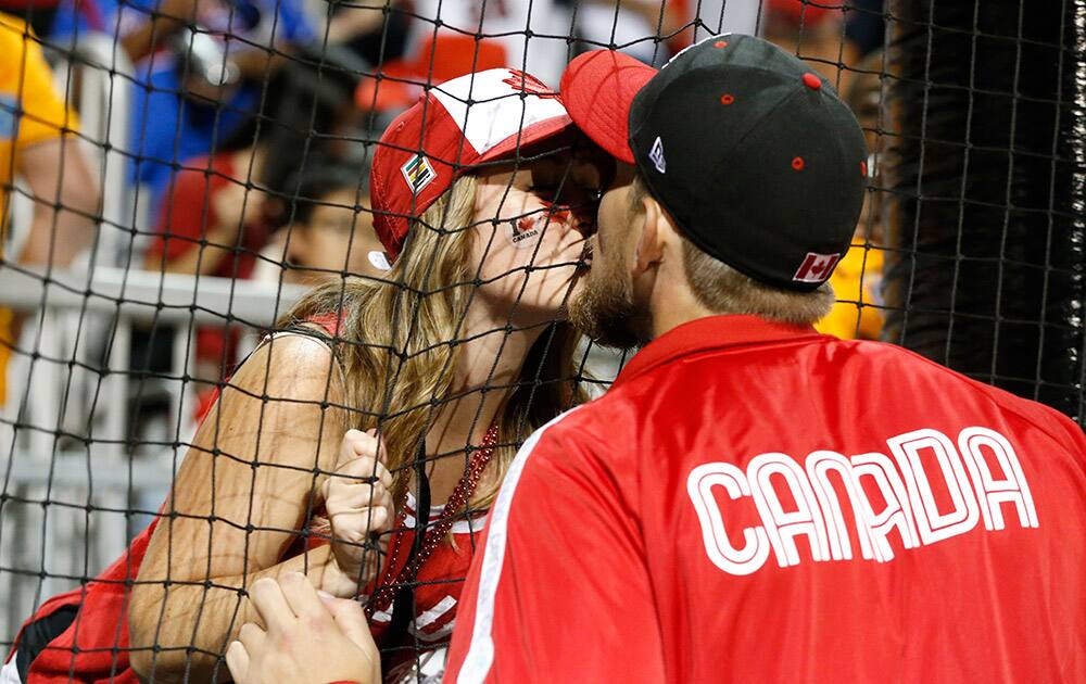 Canada's Jordan Lennerton gives a kiss to his fiancee Ashley Swistzew after he was awarded the gold medal during the baseball tournament medal ceremony at the Pan Am Games in Ajax, Ontario.