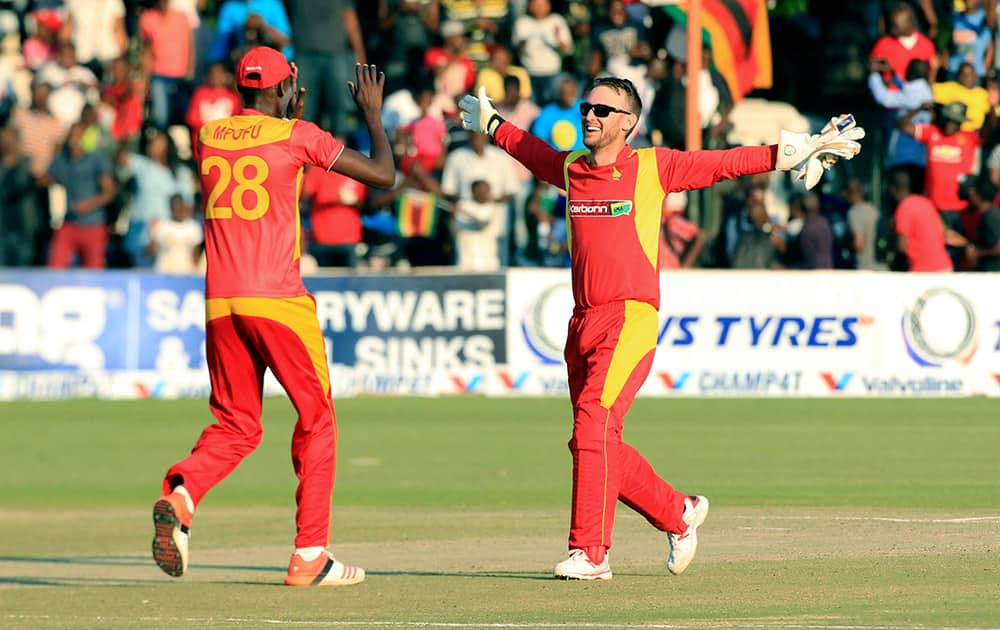 Zimbabwean players Christopher Mpofu and Sean Williams celebrate after beating India in their Twenty20 cricket match in Harare, Zimbabwe.