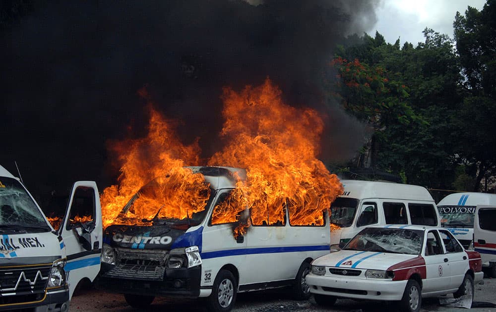 A taxi bus burns after a fight broke out between rival taxi unions fighting for permits in the city of Chilpancingo, Mexico.