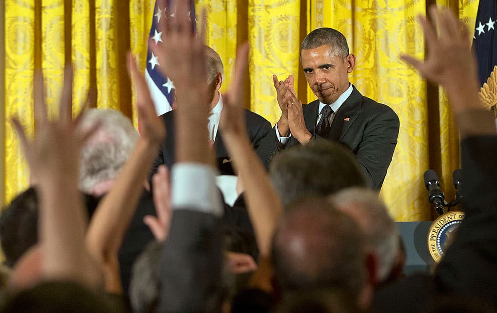 President Barack Obama applauds on stage after speaking at a reception in the East Room of the White House in Washington.