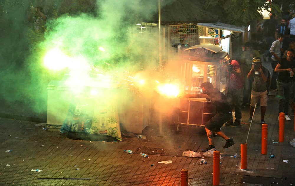 A protester fires a projectile at police in central Istanbul, during clashes following a protest denouncing the deaths of dozens of people in an explosion in southeastern Turkey. 