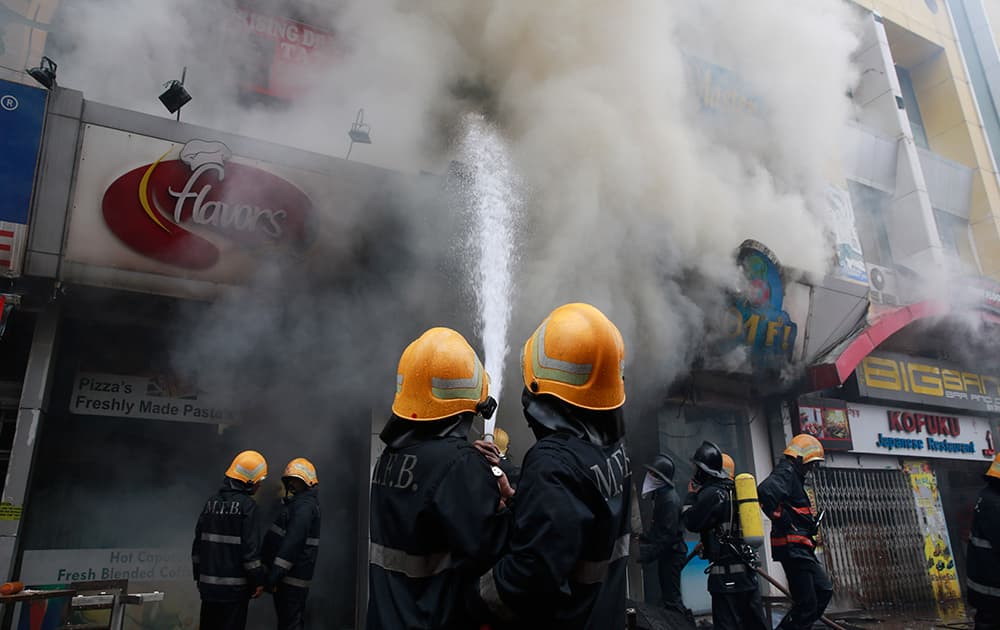 Firefighters try to douse fire after row of shops caught fire in Mumbai.