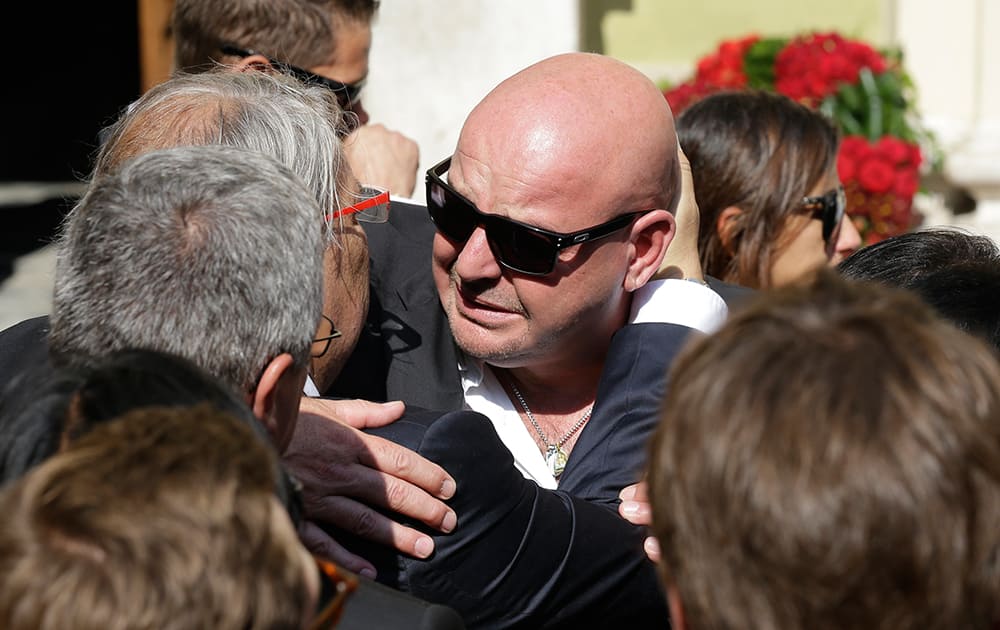 Philippe Bianchi, the father of French Formula One driver Jules Bianchi, is comforted by a relative prior to the funeral of his son at Sainte Reparate Cathedral in Nice, French Riviera.