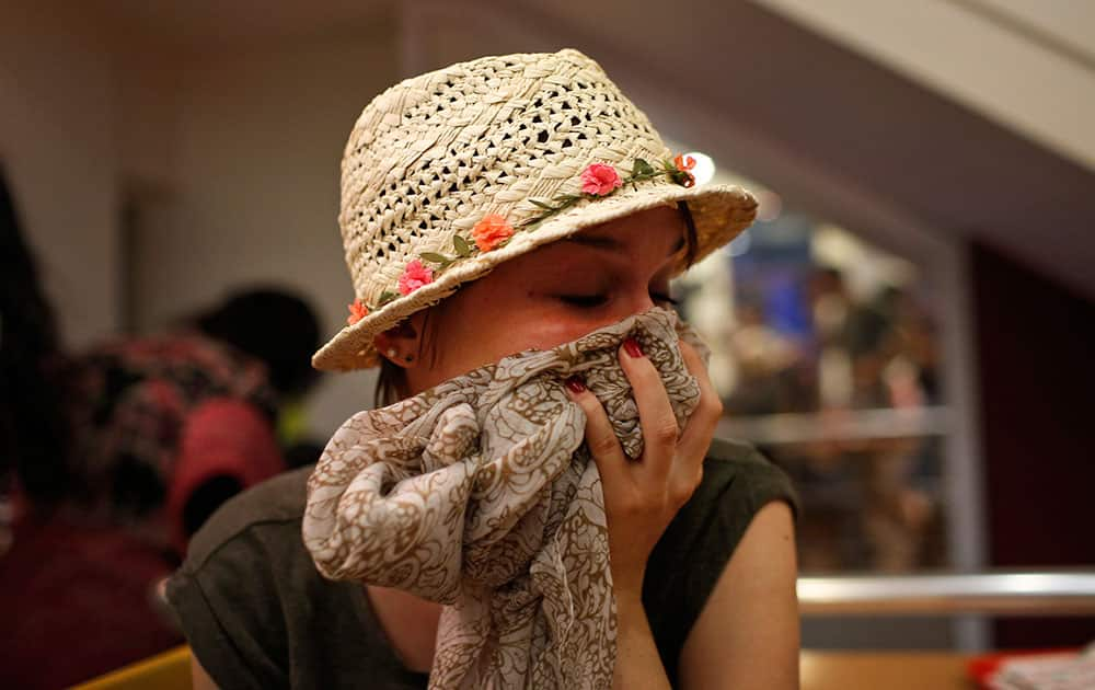 A protester tries to protect herself from the effects of tear gas fired by police in Istanbul.