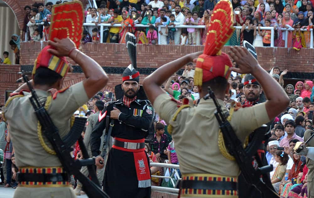 Indian Border Security Force soldiers and Pakistani Rangers, in black, perform the daily retreat ceremony at the India-Pakistan joint border check post of Attari-Wagah near Amritsar, India.