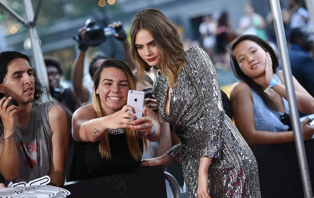 Actress Cara Delevingne poses with a fan at the premiere of 