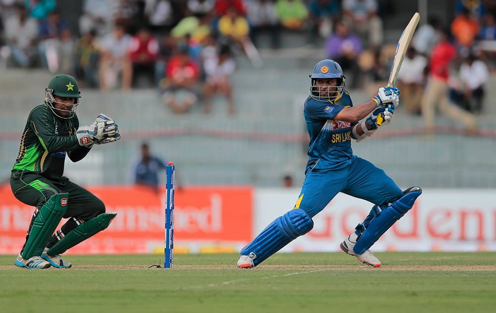 Sri Lanka's Tillakarathne Dilshan plays a shot as Pakistan's wicketkeeper Sarfraz Ahmed watches during their fourth one day international cricket match with Pakistan in Colombo, Sri Lanka.