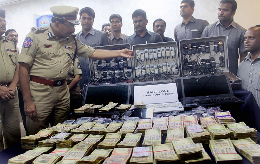 Police showing cash and mobiles recovered after bust of cricket betting racket in Hyderabad.