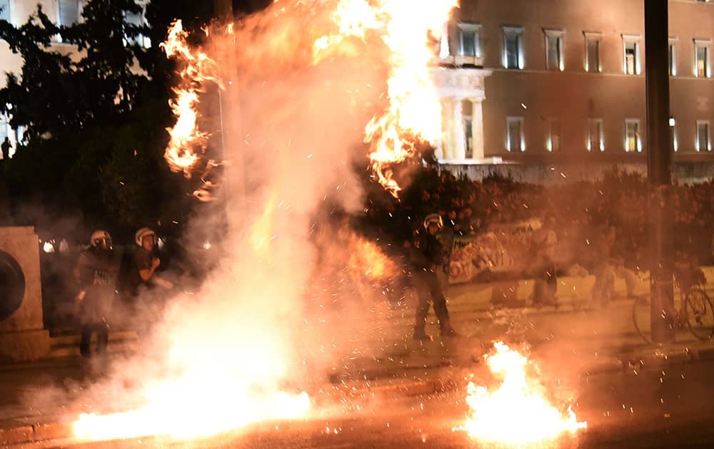 Riot policemen try to avoid a petrol bomb thrown by anti-austerity protesters during a rally outside the Greek Parliament in Athens.