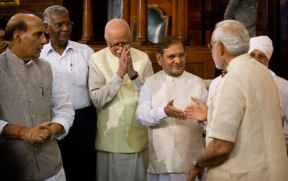 Prime Minister Narendra Modi, greets Janata Dal party leader Sharad Yadav as Indian Home minister Rajnath Singh, left and Communist party of India leader D. Raja, second left watch and Bharatiya Janata Party senior leader L.K. Advani, greets during the function to pay floral tributes to Bal Gangadhar Tilak in New Delhi.