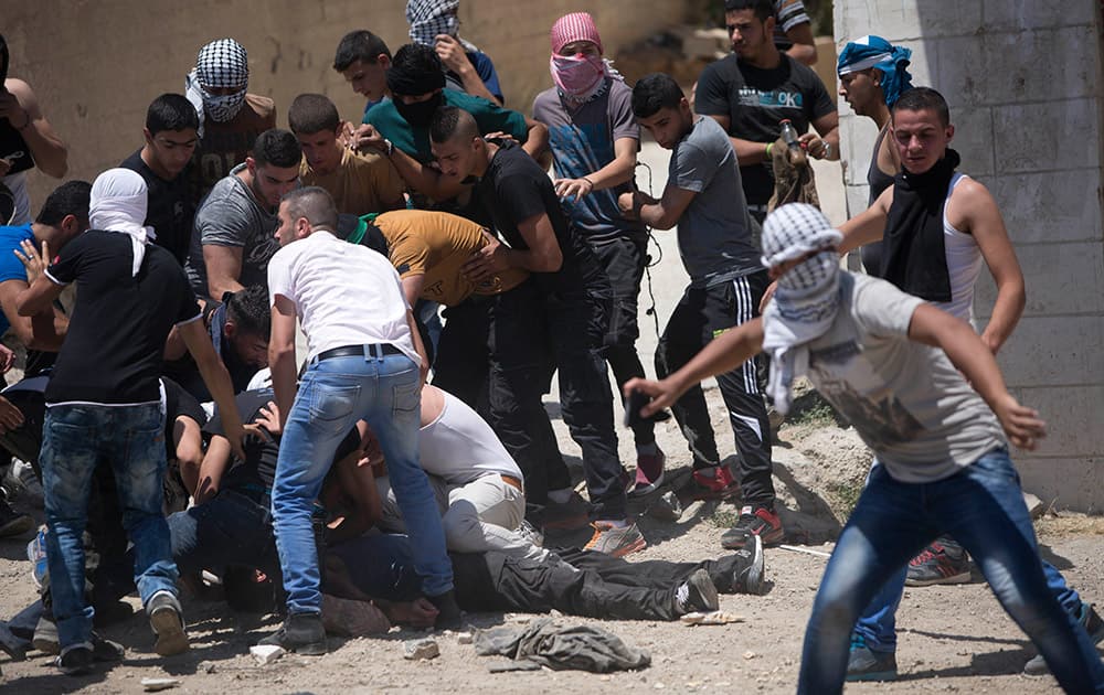 Palestinians carry a youth injured from live bullets fired by Israeli soldiers during clashes after the funeral of Falah Abu Maria in the village of Beit Omar near the West Bank city of Hebron.
