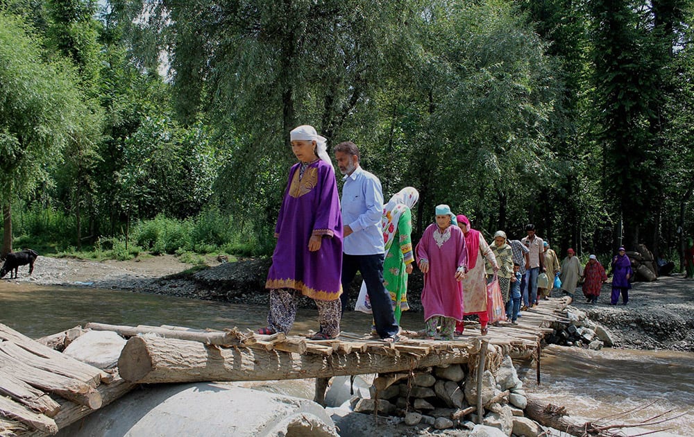 Villagers cross Chandri river using makeshift wooden bridge at Chandrigam in south Kashmir’s Pulwama district. The concrete bridge and some other foot bridges on the river have been washed off by cloudbursts and floods.