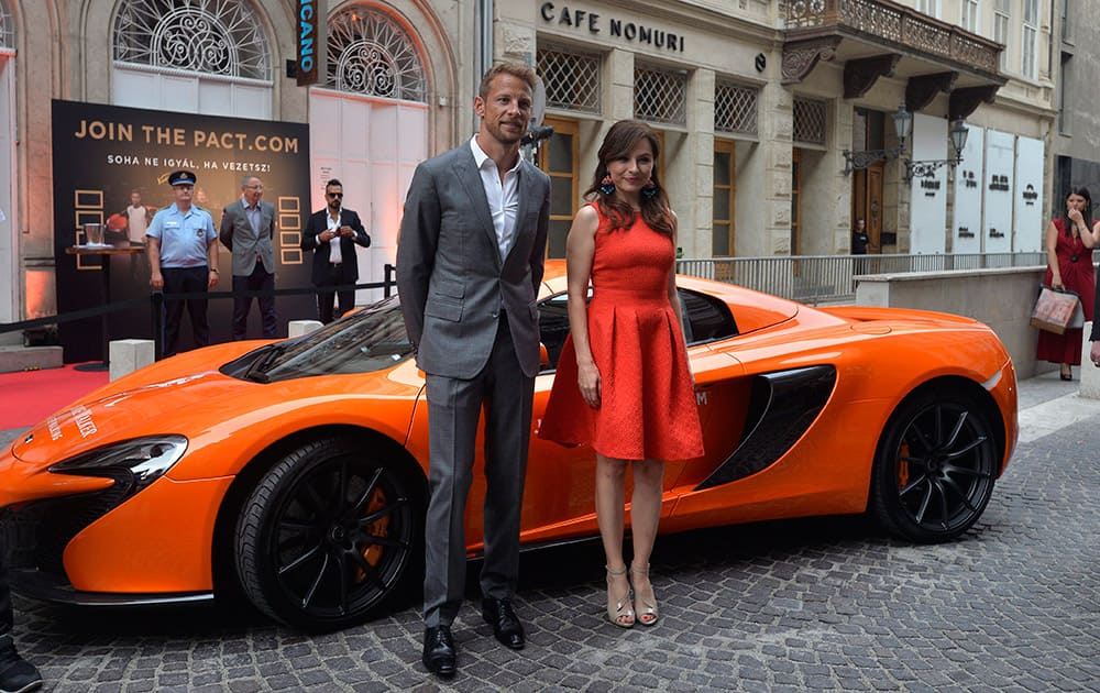 British Formula One driver Jenson Button of McLaren Honda and Hungarian singer Adrienn 'Zseda' Zsedenyi arrive for the Joint The Pact – Never Drink And Drive safety drive campaign event with Button's McLaren 650S Spider in Budapest, Hungary.