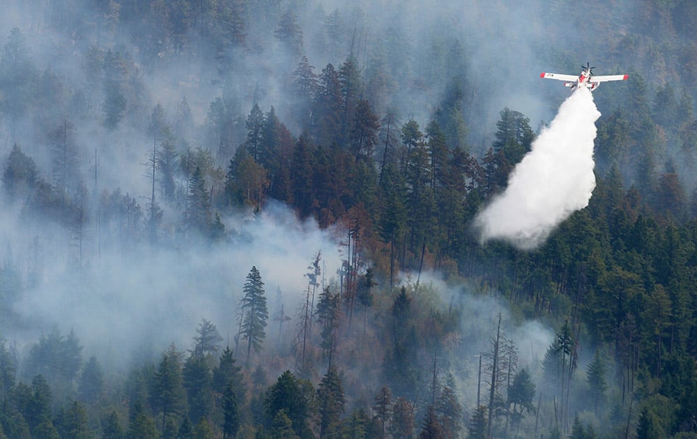 A water bomber drops its load on a wildfire near Kelowna, British Columbia.