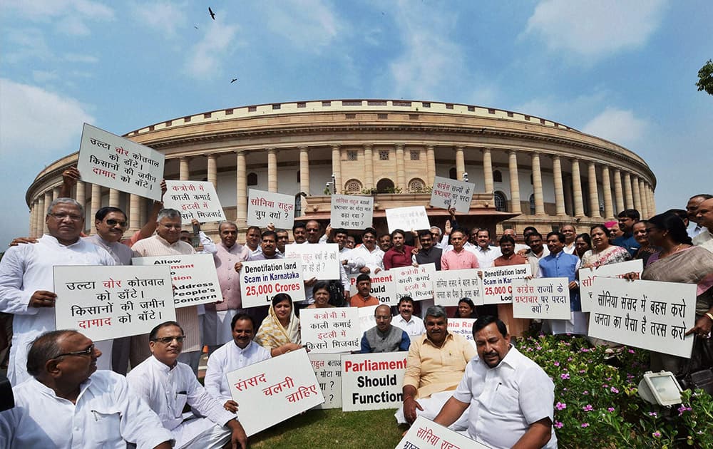 BJP MPs hold placards during a protest near Mahatma Gandhi statue against Congress party for not allowing Parliament to function during the monsoon session, in New Delhi.