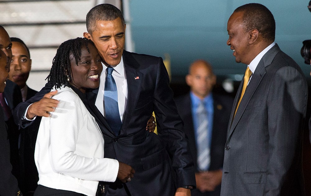 Kenyan President Uhuru Kenyatta, right, watches as President Barack Obama, center, hugs his half-sister Auma Obama, after he arrived at Kenyatta International Airport, in Nairobi, Kenya.