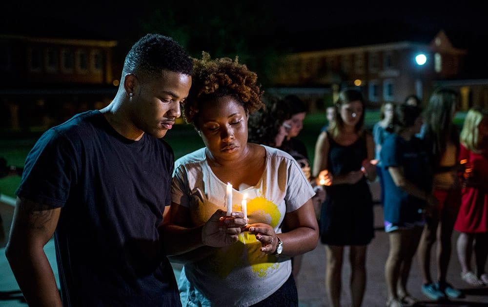 Sheldon Gilton, a business student, and Brea Butler, a psychology student, pray during a candlelight vigil for The Grand 16 theater shooting victims at the University of Louisiana at Lafayette in Lafayette, La. John Russell Houser stood up about 20 minutes into Thursday night's showing of 'Trainwreck' and fired on the audience with a semi-automatic handgun.