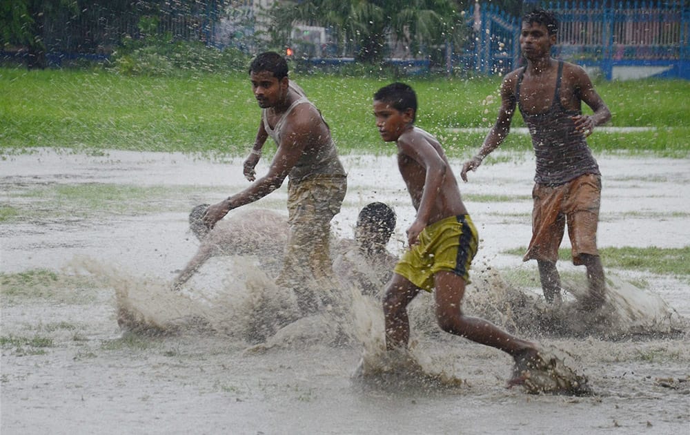 Boys play at a waterlogged ground after heavy rain in Kolkata.