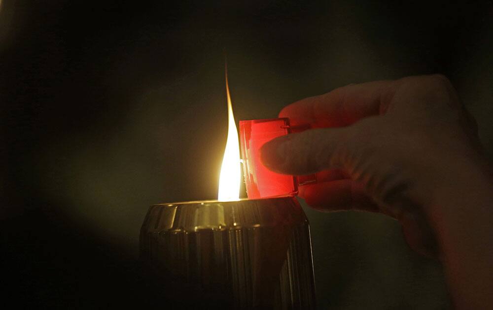 People light candles on the altar during a prayer service for the victims of The Grand 16 theater shooting at the Cathedral of St. John the Evangelist, in Lafayette, La.