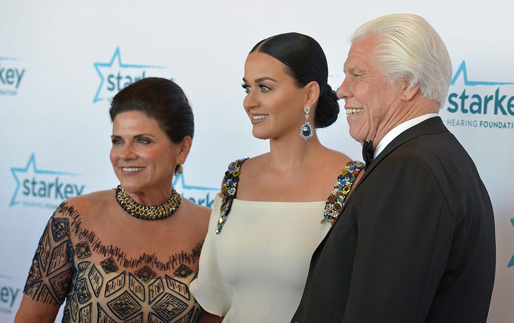 Katy Perry, center, poses with Starkey Hearing Foundation founders Tani Austin, left, and Bill Austin during the Starkey Foundation’s annual gala in St. Paul, Minn.