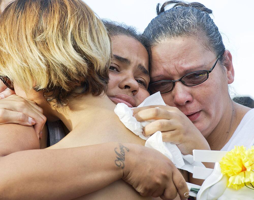 Mary Kirkland, center, the mother of shooting victim Shakur Franklin, hugs Vanessa Belen, left, the mother of shooting victim Elijah Jackson, during a memorial,  in Erie, Pa. 