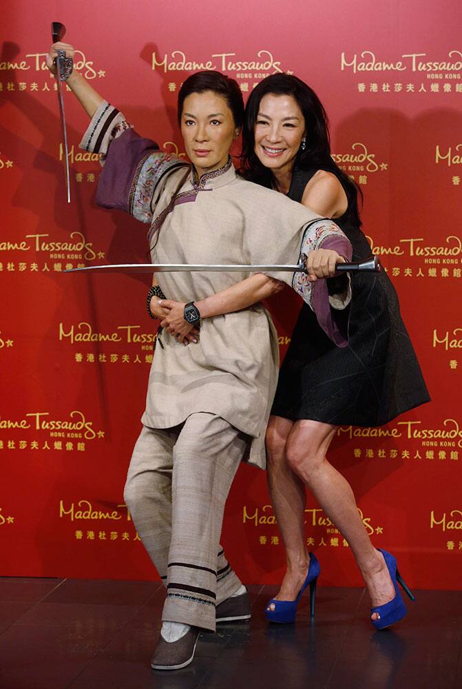 Malaysian martial arts actress Michelle Yeoh poses with her new wax figure at Madame Tussauds in Hong Kong.