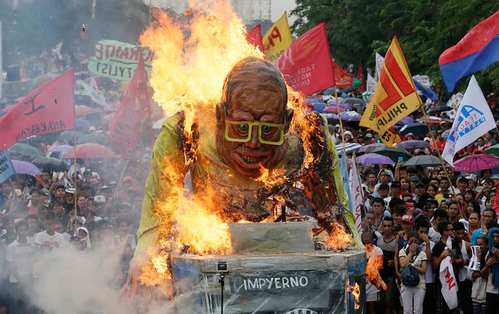 Protesters set on fire to the giant effigy of Philippine President Benigno Aquino III during a rally leading to the House of Representatives to coincide with Aquino's last State-of-the-Nation-Address or SONA at suburban Quezon city northeast of Manila, Philippines.