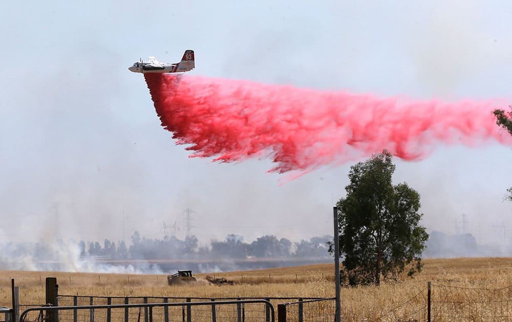 An air tanker drops a load of fire retardant while fighting a large grass fire in Elverta, Calif.
