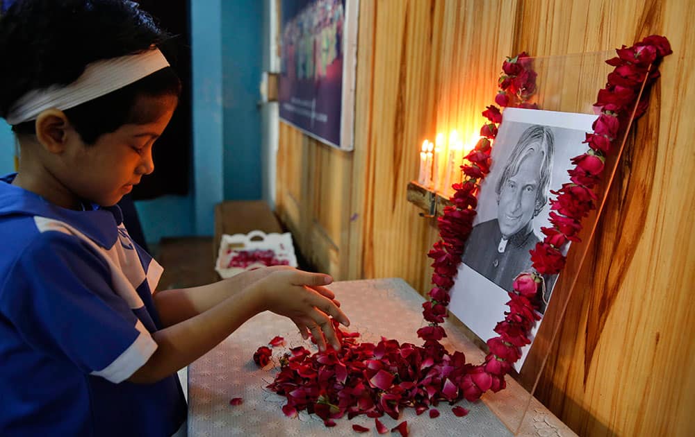 A student offers flowers to a portrait of former President A.P.J. Abdul Kalam at CMS School in Lucknow, India.