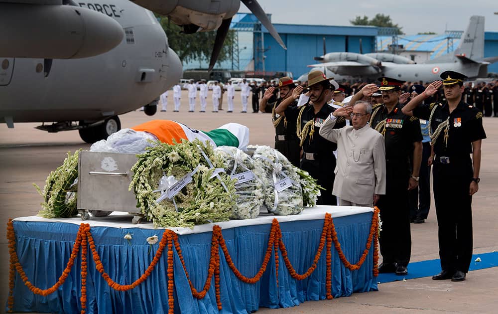 President Pranab Mukherjee, foreground, salutes the flag-draped casket of former President A.P.J. Abdul Kalam after his body arrived at the Palam airport in New Delhi, India.