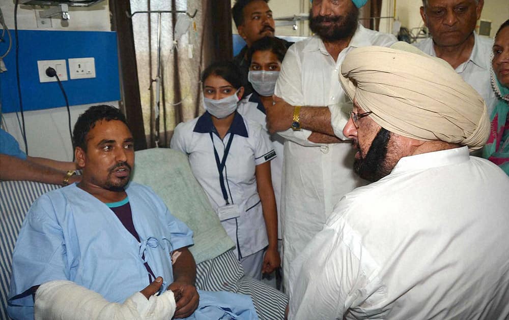 Former Chief Minister Captain Amarinder Singh interacts with an injured victim of Dinanagar militant attack, at a hospital in Gurdaspur.