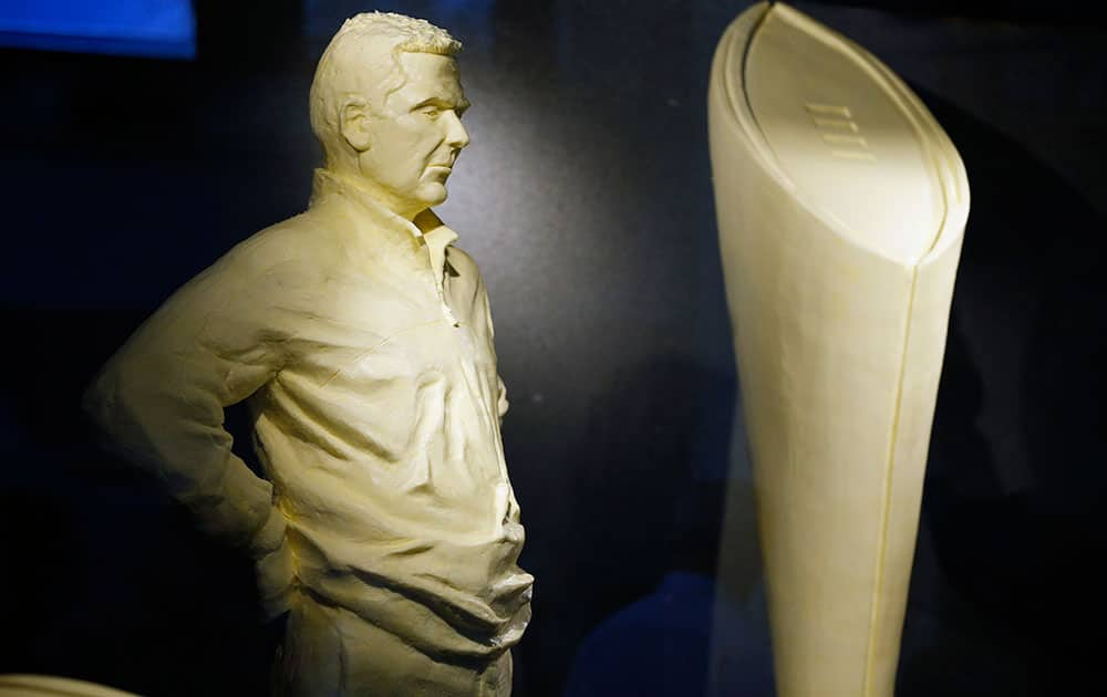 A butter sculpture depicting Ohio State NCAA football coach Urban Meyer, left, and the national championship trophy are displayed in the dairy building at the Ohio State fairgrounds, in Columbus, Ohio. 