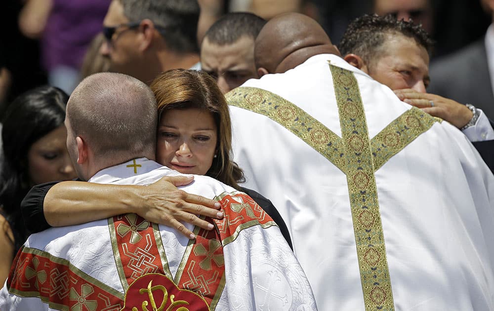 Dondie LeBlanc Breaux, left, and Kevin Breaux, parents of Mayci Breaux, are hugged by clergy outside the Church of the Assumption, after her funeral in Franklin, La.