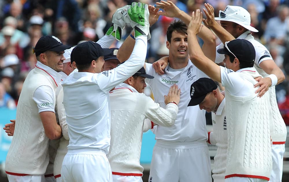 England’s Steven Finn celebrates withteam-mates after bowling Australia’s Michael Clarke for 10 runs during day one of the third Ashes Test cricket match, at Edgbaston, Birmingham, England.