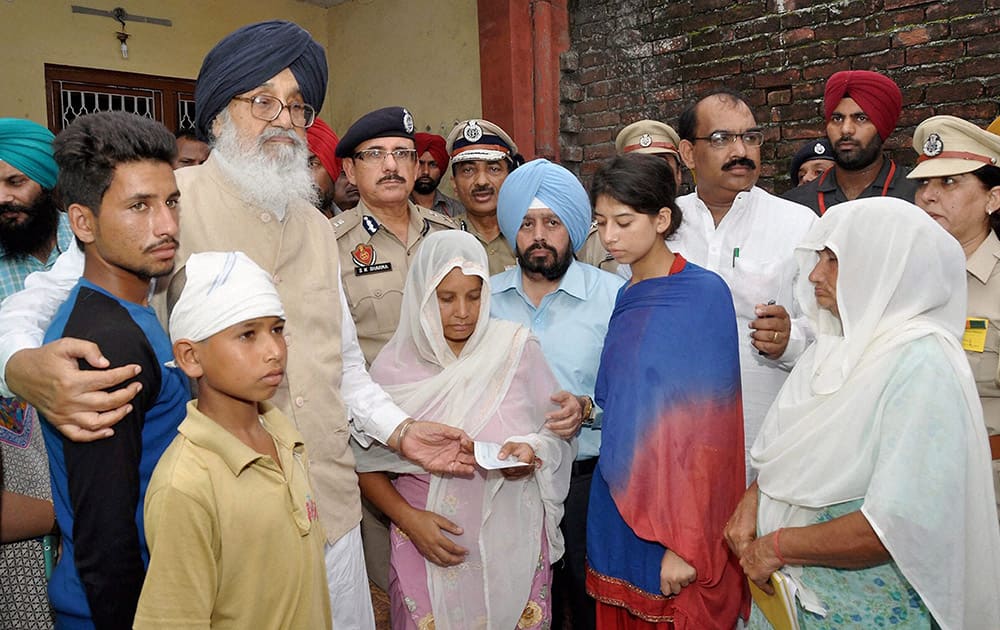 Punjab Chief Minister Parkash Singh Badal presents a cheque to the bereaved family members bereaved family members of Home Guard Jawan Sukhdev Singh at village Attepur in Pathankot.