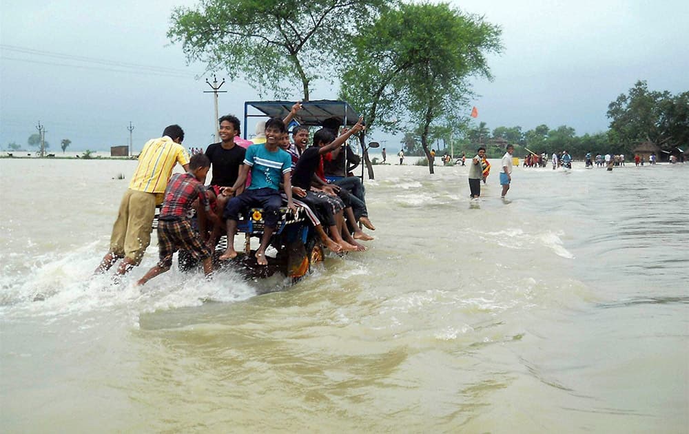 Locals wade through flood water at Karalaghat road in Burdwan district of West Bengal.