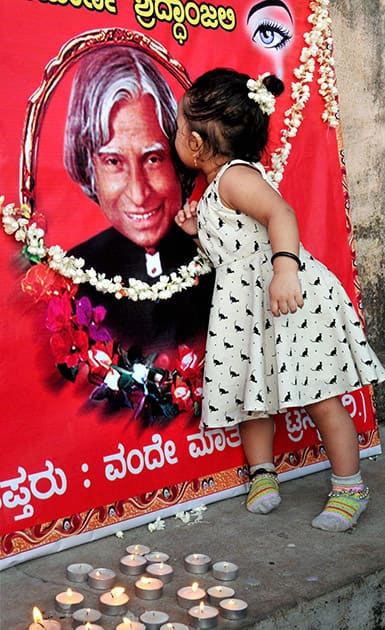 A child kisses former President APJ Abdul Kalams photo at Chikmagalur in Karnataka.