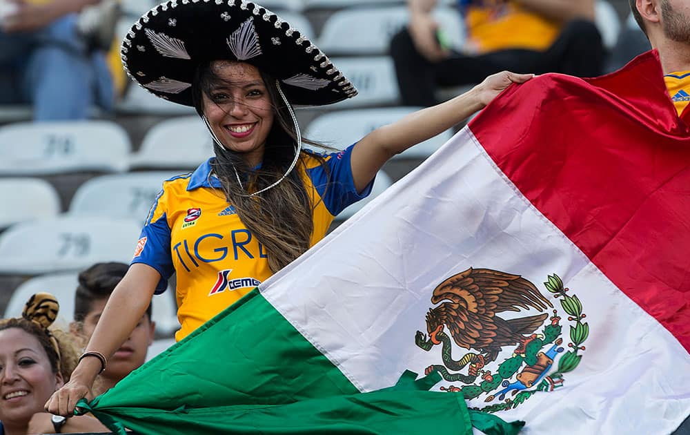 A fan of Mexico's Tigres holds up a Mexican flag prior to the start of the game against Argentina's River Plate during the first leg soccer match of the final of the Copa Libertadores in Monterrey, Mexico.