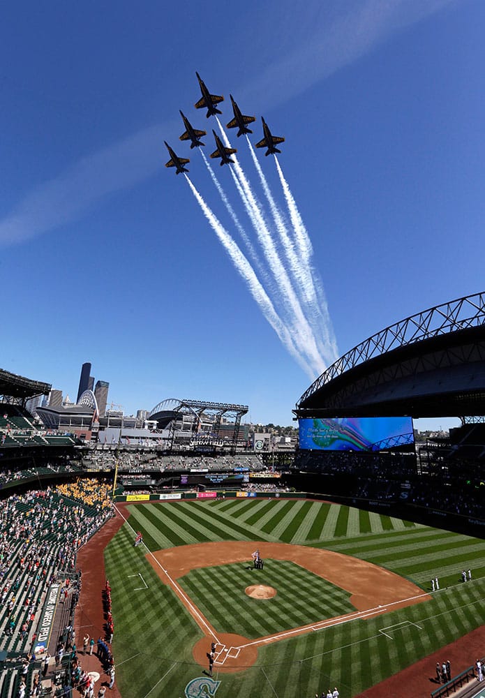 embers of the U.S. Navy Blue Angels fly in formation over the Seattle Mariners' ballpark, Safeco Field, before a baseball game against the Arizona Diamondbacks in Seattle.