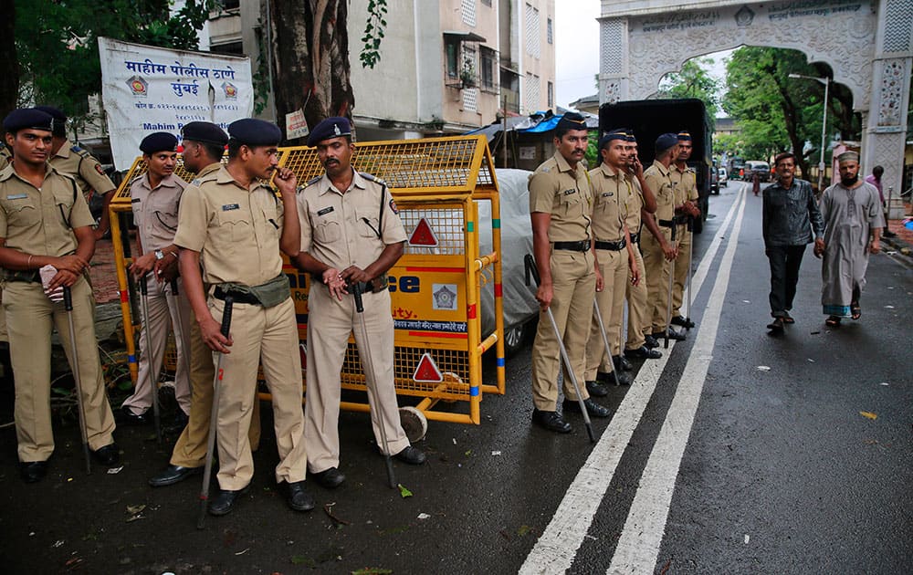 policemen stand guard in the neighborhood of Yakub Abdul Razak Memon's family residence in Mumbai.