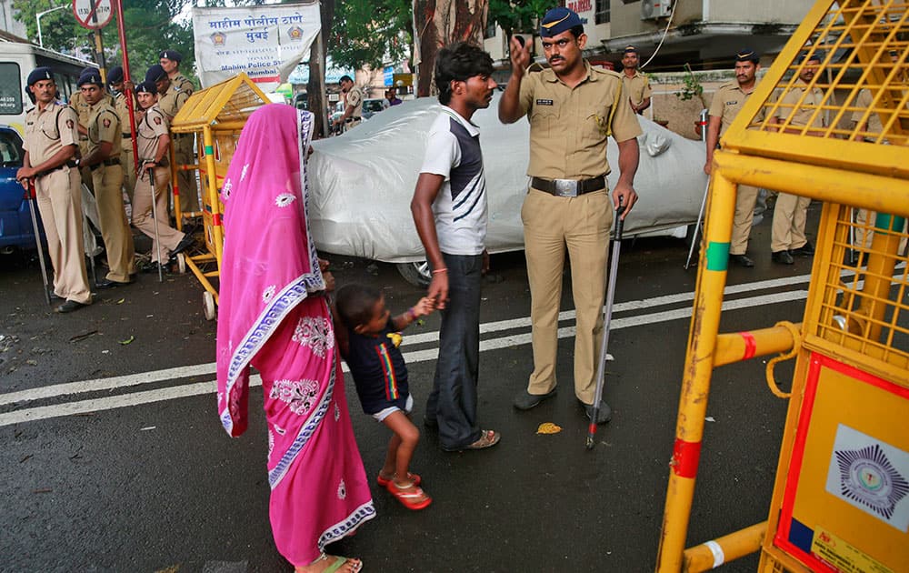 police officer stops a family at a barricade in the neighborhood of Yakub Abdul Razak Memon's family residence in Mumbai.