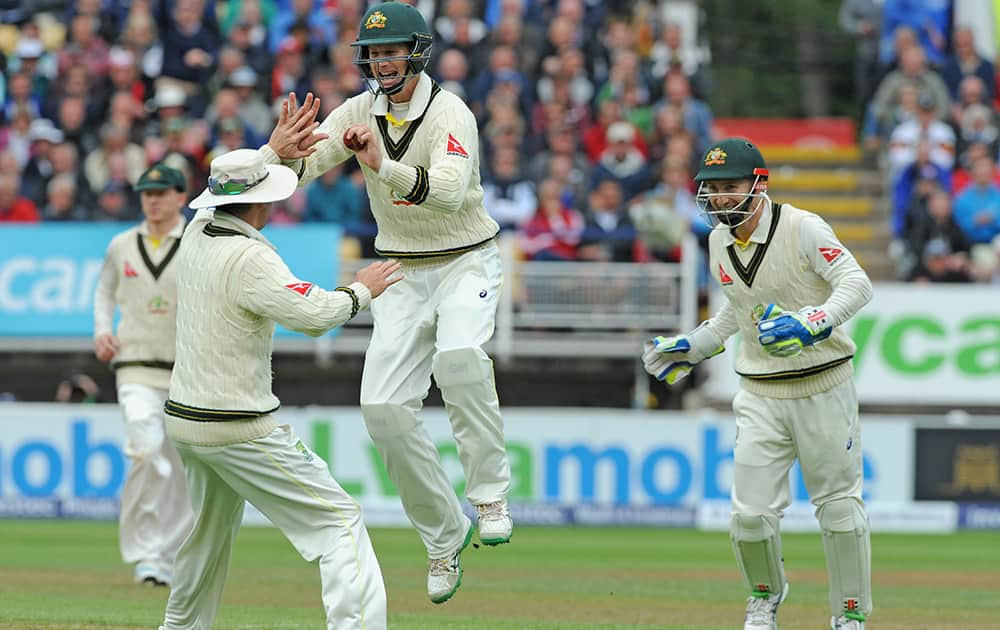 Australia’s Adam Voges celebrates with Michael Clarke and Peter Nevill after he caught England’s Alastair Cook bowled Australia’s Nathan Lyon for 36 runs during day one of the third Ashes Test cricket match, at Edgbaston, Birmingham, England.