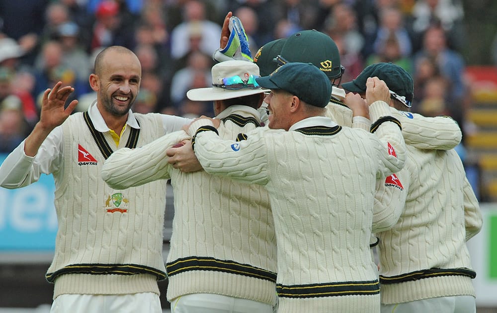 Australia’s Nathan Lyon celebrates with team mates after he bowled England’s Alastair Cook caught Adam Voges for 36 runs during day one of the third Ashes Test cricket match, at Edgbaston, Birmingham, England.