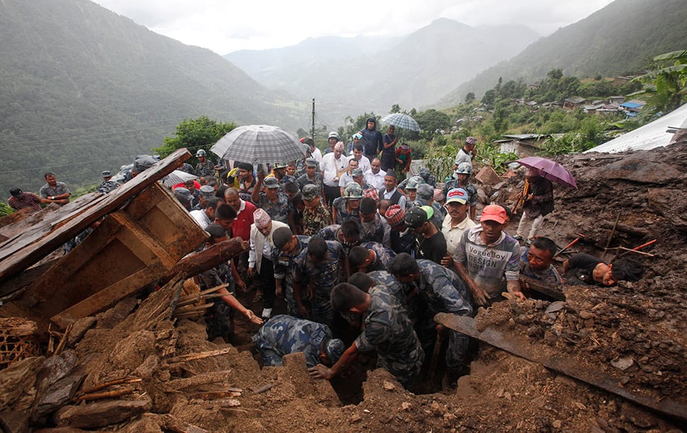 Nepalese policemen search for bodies of victims from the debris after a landslide in Lumle village, about 200 kilometers (125 miles) west of Kathmandu, Nepal.