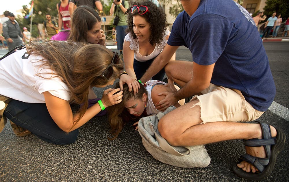 People help a wounded person after Yishai Schlissel, an ultra-Orthodox Jew, attacked people with a knife during a gay pride parade in Jerusalem.