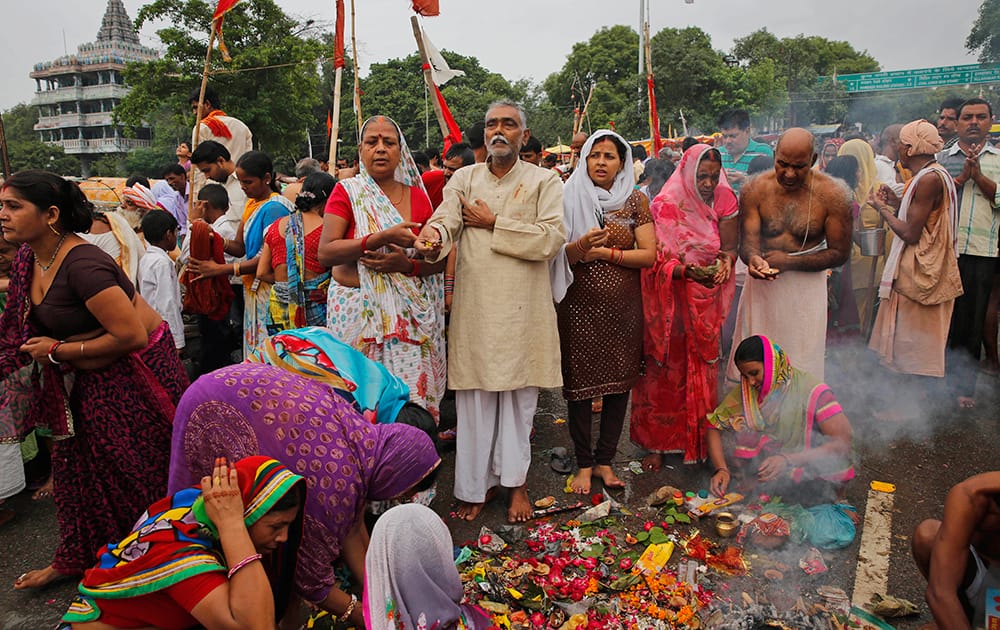 Hindu devotees pray after taking a holy dip at Sangam, the confluence of the Rivers Ganges, Yamuna the mythical Saraswati, on the occasion of Guru Purnima, or full moon day dedicated to the Guru, in Allahabad.