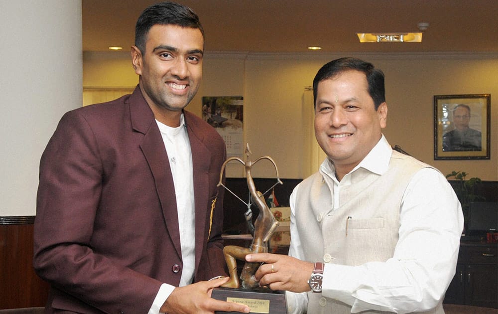 Sports Minister Sarbananda Sonowal honours Off-spinner Ravichandran Ashwin with the Arjuna Award which was conferred on him last year, in New Delhi.