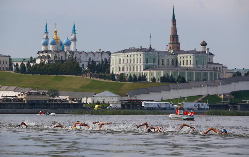 Athletes pass by the Tatarstan Presidential Palace as they compete in the men's 25km open water event at the Swimming World Championships in Kazan, Russia.